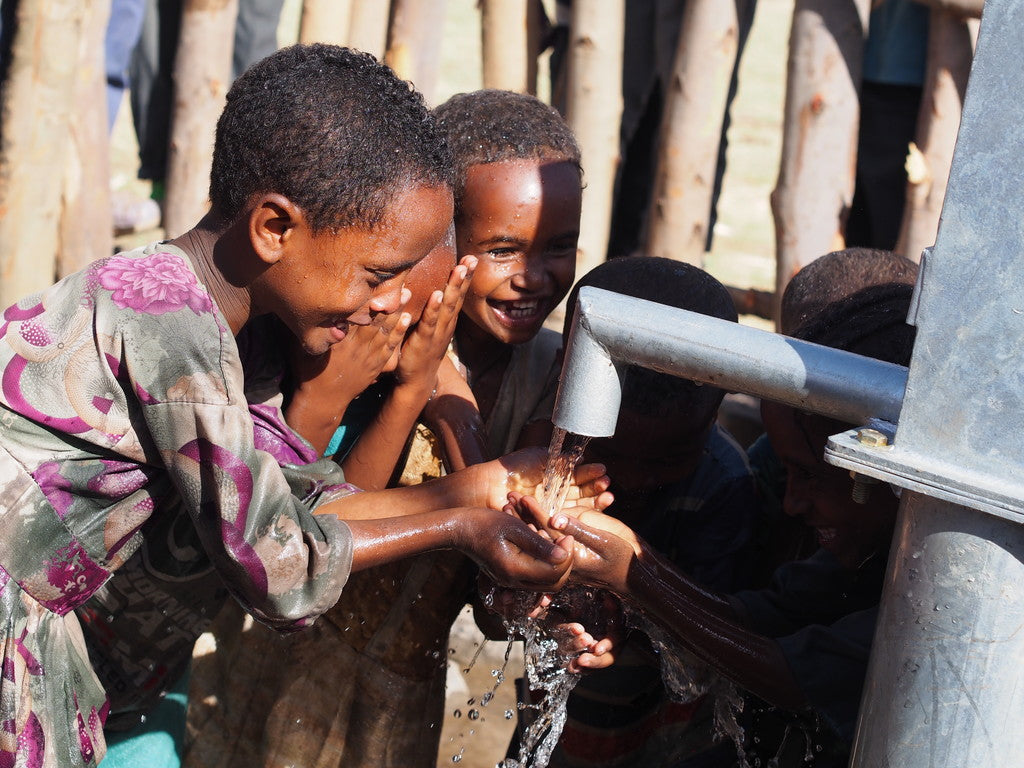 Image of children in Ethiopia receiving fresh water from water well.